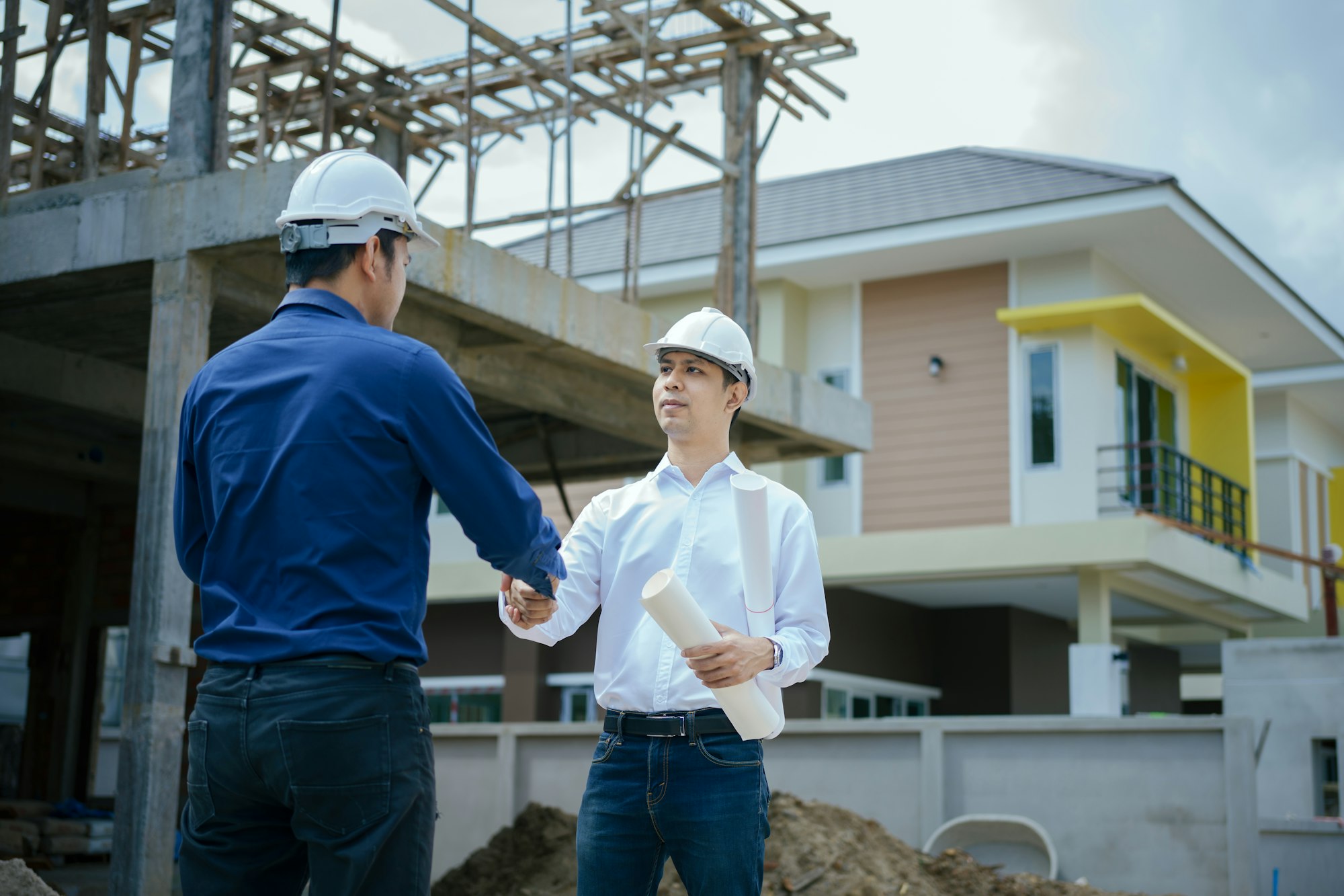 Engineers man handshake at construction site.